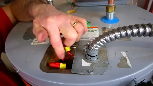 Hand using a socket tool at the top of a tank water heater