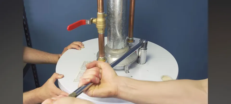 Technician working on piping above a tank water heater