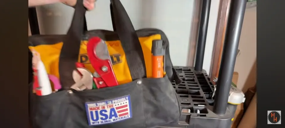 Tool bag containing hand tools beside a water heater